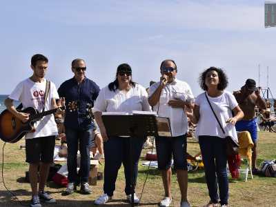 Ma ecco che parte lo �spettacolo�. Si comincia con la musica. Un coro accompagnato dalle note di una chitarra attira passanti e bagnanti...